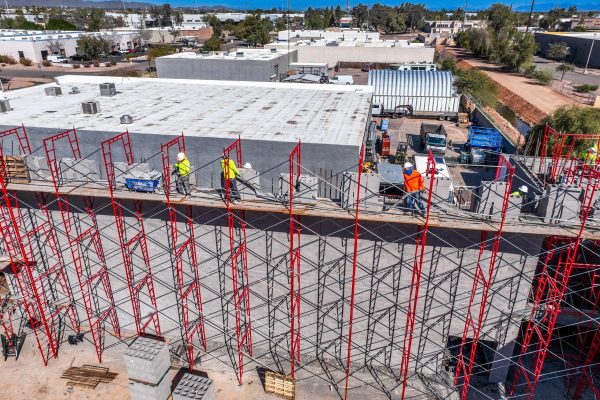 Hirschi Masonry workers working on a large red scaffold building a big building. Hirschi Masonry of Las Vegas, Nevada